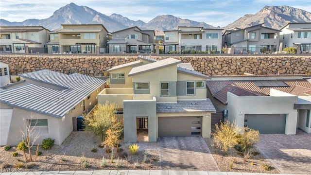 multi unit property featuring central AC unit, a garage, and a mountain view