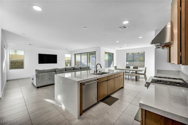 kitchen with sink, ventilation hood, a healthy amount of sunlight, a center island with sink, and stainless steel dishwasher