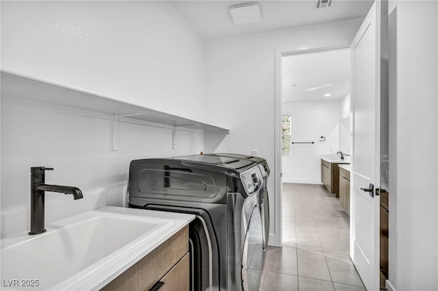 washroom with washer and dryer, sink, and light tile patterned floors