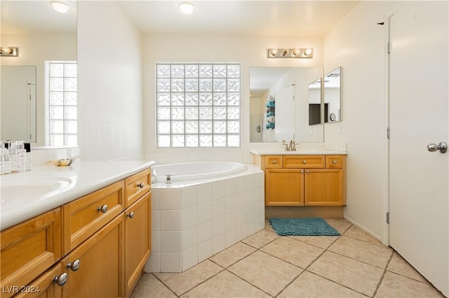 bathroom featuring tile patterned floors, tiled bath, and vanity