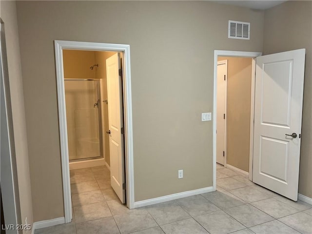 unfurnished bedroom featuring ensuite bath, light tile patterned floors, baseboards, and visible vents