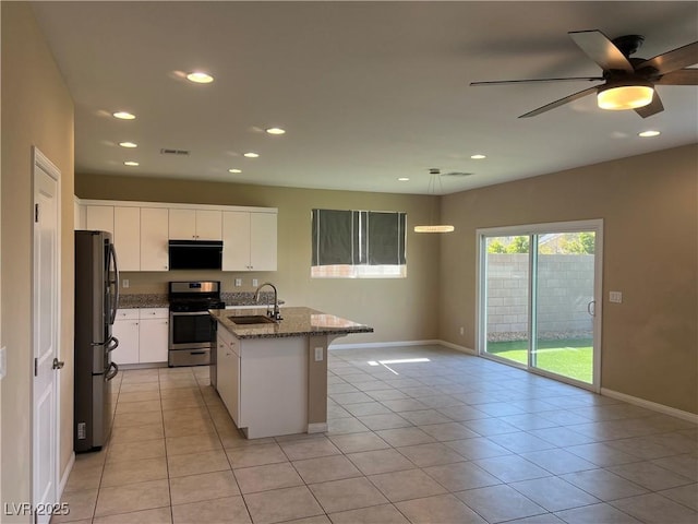 kitchen featuring dark stone counters, stainless steel appliances, light tile patterned floors, and white cabinets