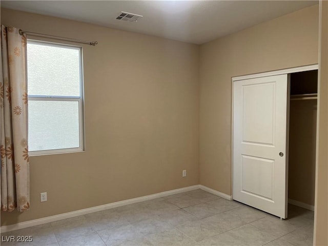 unfurnished bedroom featuring a closet, visible vents, and baseboards