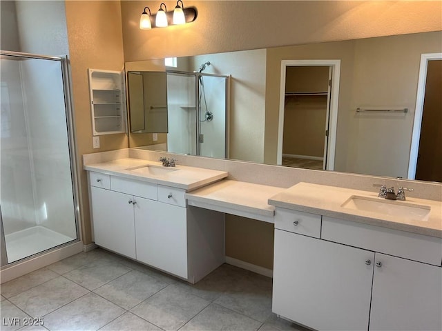 full bathroom featuring tile patterned flooring, a shower stall, and a sink