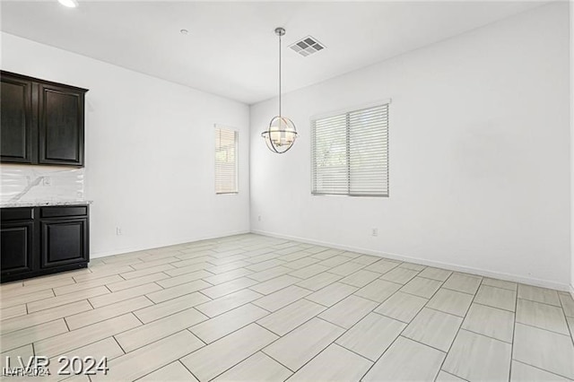 unfurnished dining area with a notable chandelier