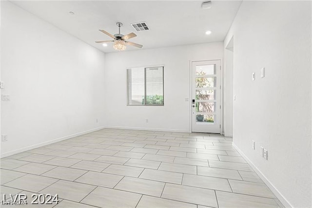 tiled spare room with ceiling fan