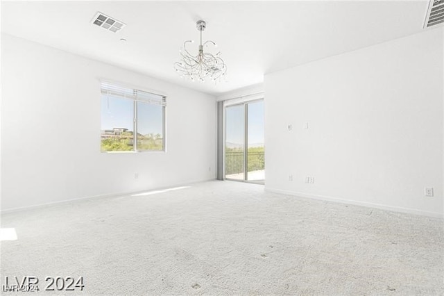 empty room featuring carpet and a chandelier