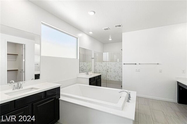 bathroom featuring separate shower and tub and vanity