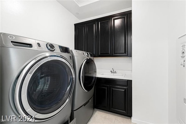 laundry room with washing machine and clothes dryer, sink, light tile patterned floors, and cabinets