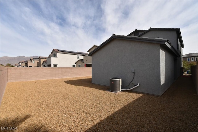 view of side of home featuring a mountain view and central AC unit