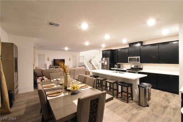 dining room featuring sink and light wood-type flooring