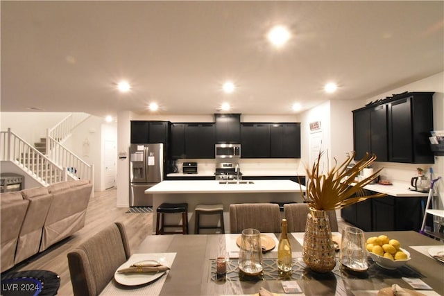 dining space with light hardwood / wood-style flooring and sink