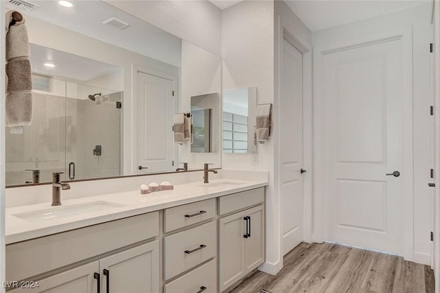 bathroom featuring hardwood / wood-style floors, vanity, and an enclosed shower