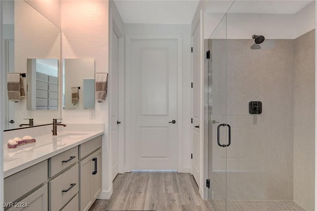 bathroom featuring hardwood / wood-style floors, vanity, and a shower with door