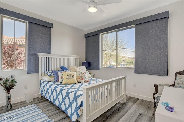 bedroom with multiple windows, ceiling fan, and wood-type flooring