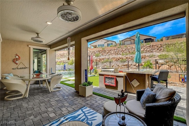 view of patio featuring exterior bar and ceiling fan