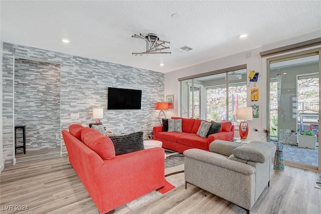 living room with light wood-type flooring and an inviting chandelier