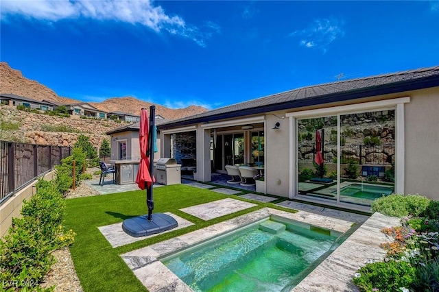 rear view of property featuring a patio, a hot tub, and a lawn