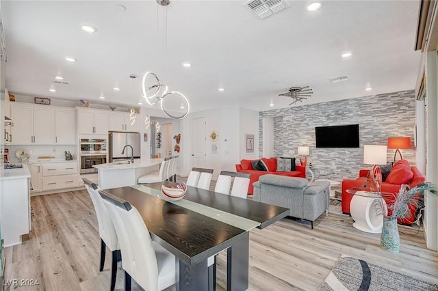 dining area with sink and light hardwood / wood-style flooring