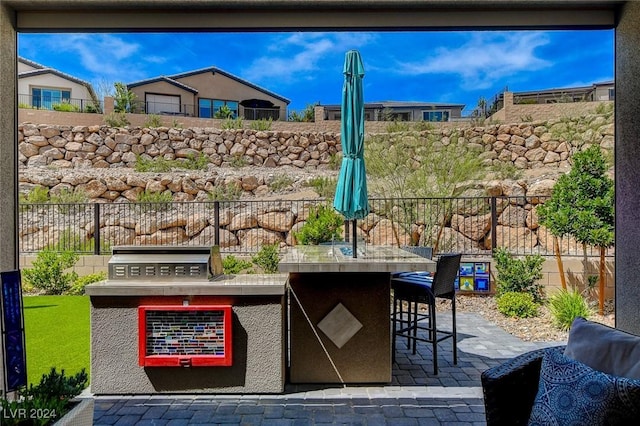 view of patio / terrace with area for grilling, a bar, and exterior kitchen