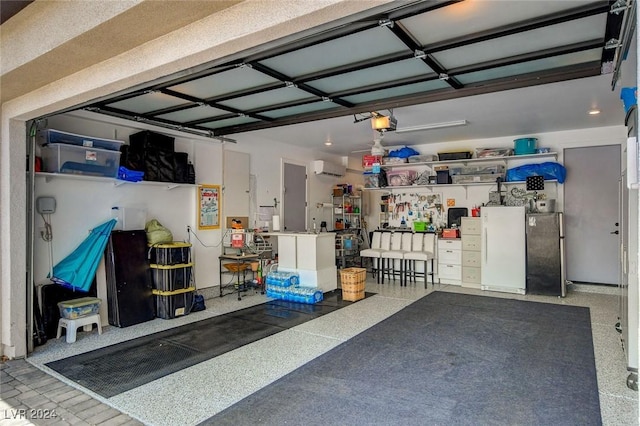 garage with a garage door opener, stainless steel refrigerator, and a wall mounted AC