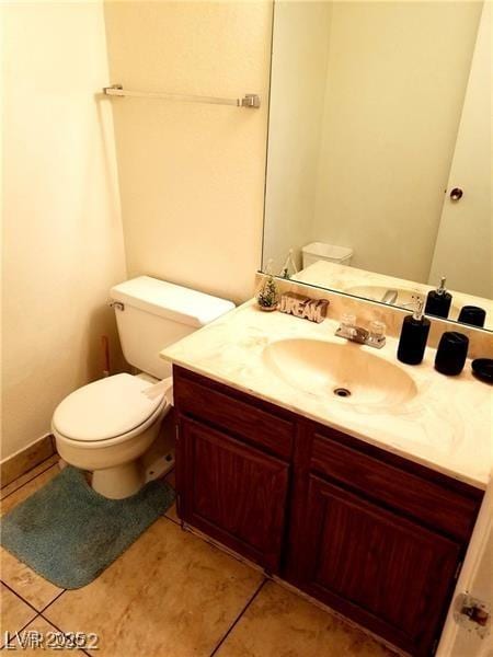 bathroom with tile patterned flooring, vanity, and toilet