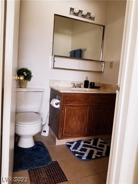 bathroom featuring tile patterned flooring, vanity, and toilet