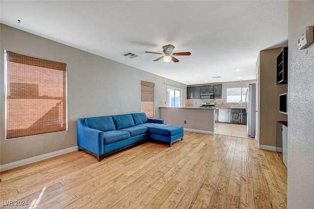 living room featuring ceiling fan and light wood-type flooring