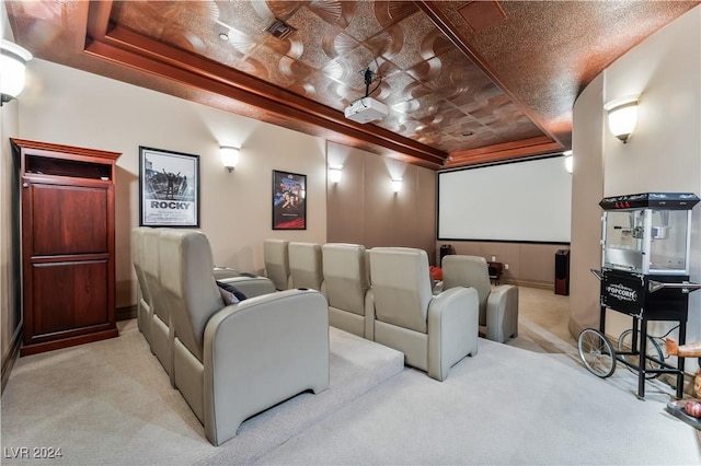 home theater room with a tray ceiling and light colored carpet