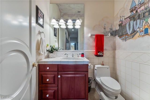 bathroom with vanity, toilet, and tile walls