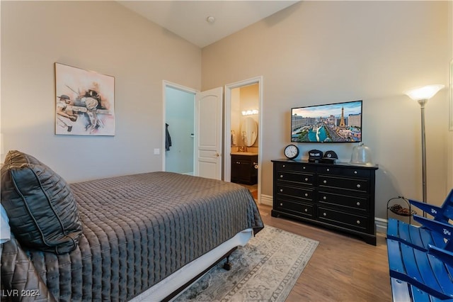 bedroom featuring light wood-type flooring and connected bathroom