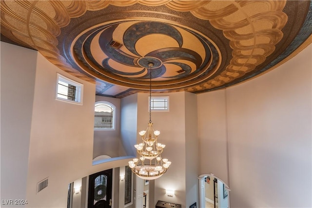 interior details with a tray ceiling and an inviting chandelier