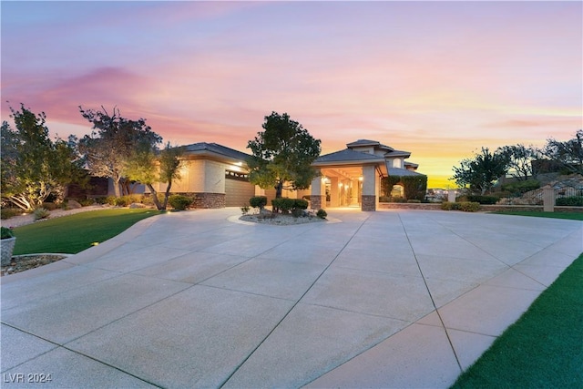 prairie-style home with a garage and a lawn