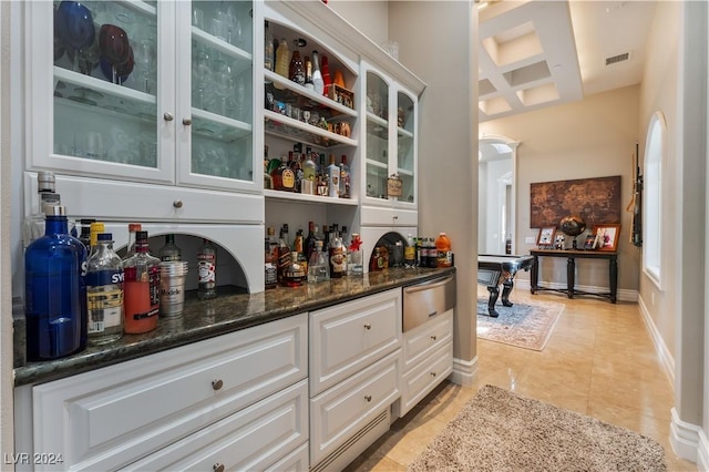 bar featuring light tile patterned flooring, white cabinetry, dark stone counters, and coffered ceiling