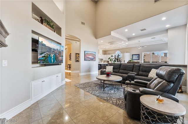 tiled living room with a tray ceiling and a towering ceiling