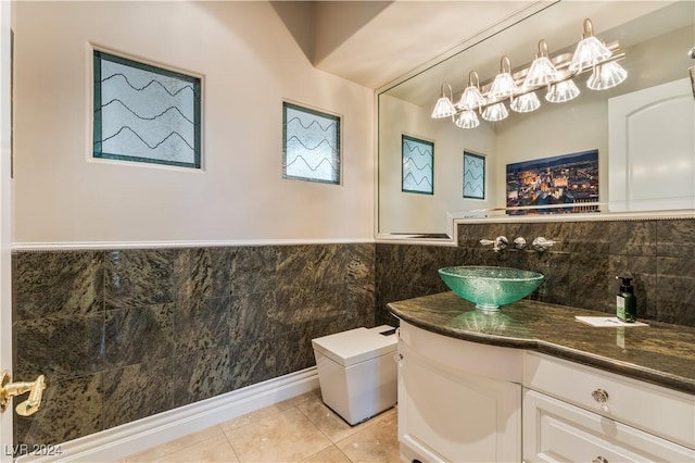 bathroom featuring tile patterned floors, vanity, toilet, and tile walls