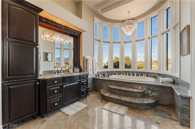 bathroom featuring an inviting chandelier, tile patterned flooring, vanity, and tiled tub