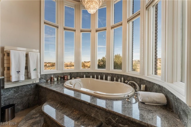 bathroom featuring a relaxing tiled tub and a chandelier