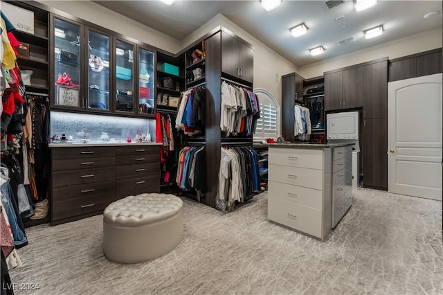 walk in closet featuring light colored carpet