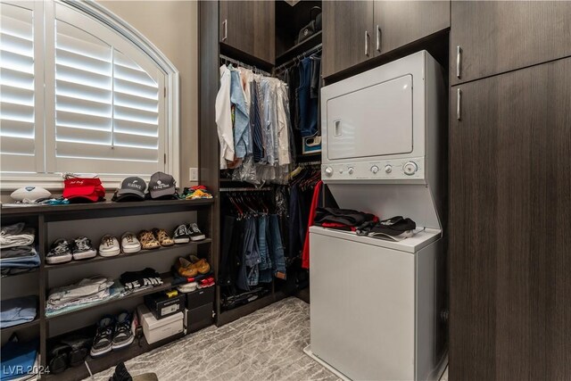 walk in closet featuring stacked washer / dryer