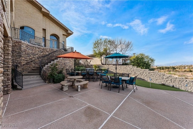 view of patio featuring outdoor dining area and stairs