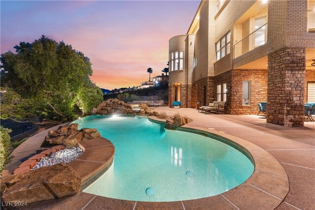 pool at dusk featuring a patio area