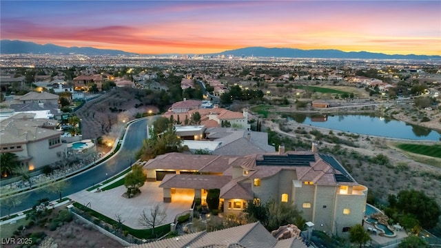 aerial view at dusk with a water and mountain view and a residential view
