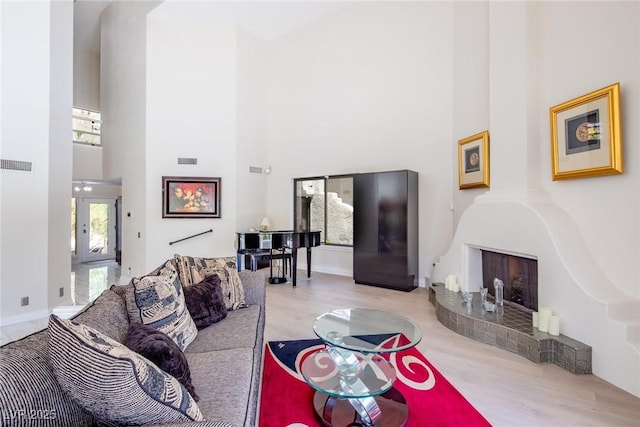 living room featuring french doors, visible vents, a high ceiling, and wood finished floors