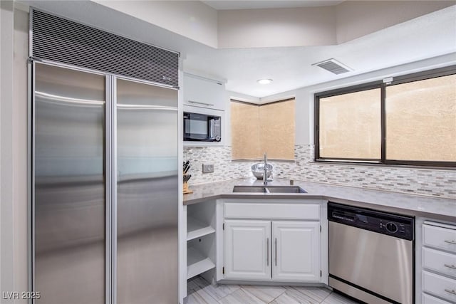 kitchen with white cabinetry, visible vents, stainless steel appliances, and a sink