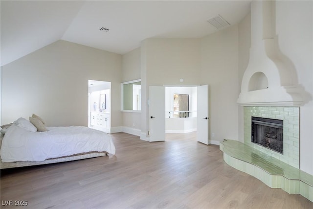 bedroom featuring a fireplace, wood finished floors, visible vents, and baseboards