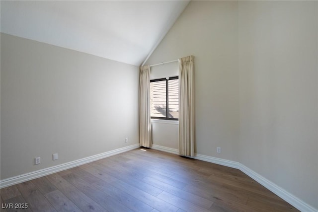 unfurnished room with high vaulted ceiling, baseboards, and wood finished floors