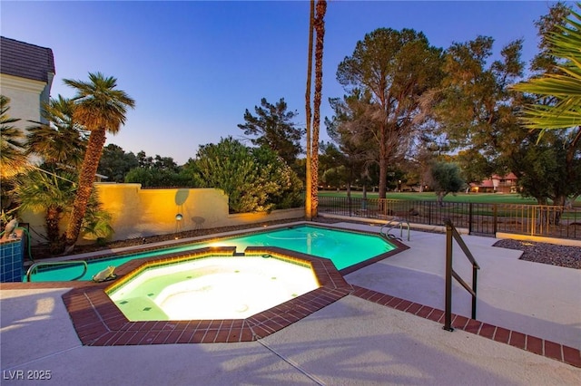 view of pool with a fenced backyard, a pool with connected hot tub, and a patio