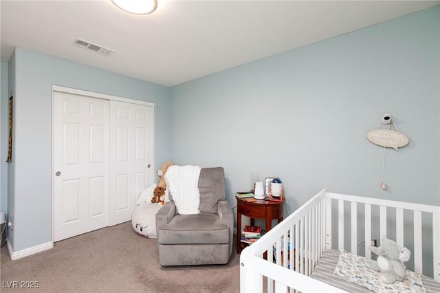 carpeted bedroom featuring a closet and a crib