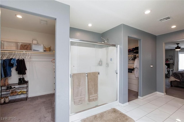 bathroom featuring a shower with door and ceiling fan